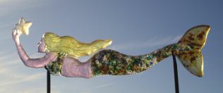 Mermaid of Estrella:  ADELLA.    Kiln cast glass sculpture.  Cold worked with selective sand blasting.  Displayed on custom black metal stand.  Measures 22Lx4.5Hx1.5W.  Contact me for pricing.