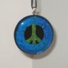 Peace Sign Pendant:
Fused glass pendant with blue border and blue/green peace sign. Measures 2 inches round. $35
