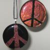 Peace Sign Pendants:
Fused glass pendants in root beer in color. Request POSITIVE (peace sign is colored) or NEGATIVE (peace sign is black) when ordering.  Measures 2 inches round. $35 each